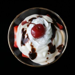 Muller Vanilla Yogurt Sundae with Strawberries, Whipped Cream, Fudge Sauce, and a Cherry
