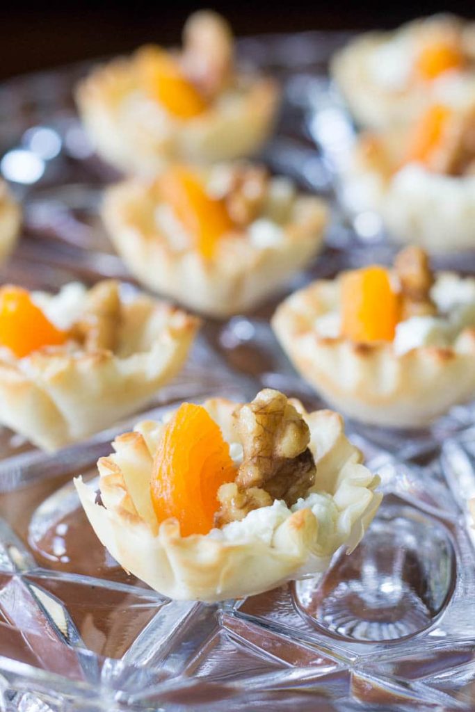 Elegant mini phyllo cups are filled with creamy goat cheese, sweet apricots, and toasted walnuts to make these goat cheese appetizer bites.