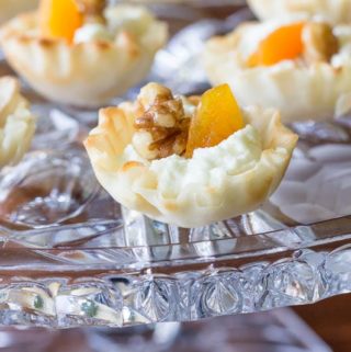 Elegant mini phyllo cups are filled with creamy goat cheese, sweet apricots, and toasted walnuts to make these goat cheese appetizer bites.