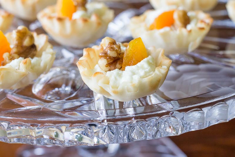 Elegant mini phyllo cups are filled with creamy goat cheese, sweet apricots, and toasted walnuts to make these goat cheese appetizer bites.