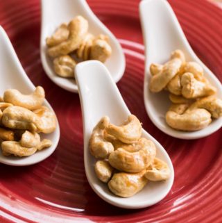 Maple glazed cashews on a red plate