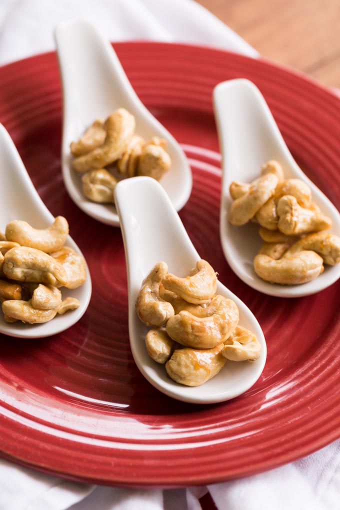 Maple glazed cashews on a red plate