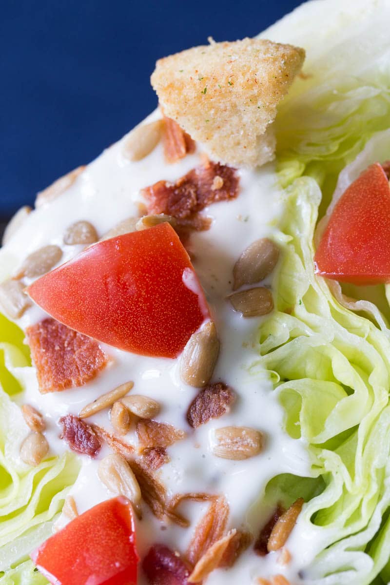 This classic wedge salad recipe is made with crisp iceberg lettuce, crumbly bacon, creamy dressing, and more. You'll love the delicious flavor and texture!