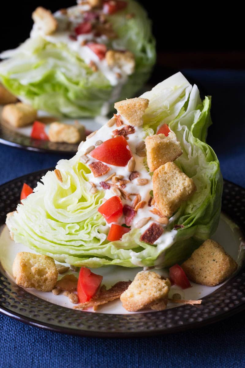 This classic wedge salad recipe is made with crisp iceberg lettuce, crumbly bacon, creamy dressing, and more. You'll love the delicious flavor and texture!