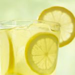 Clear glass of Chick-fil-A lemonade with round lemon slices and ice cubes