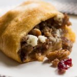 Crescent roll ring stuffed with crumbled pork sausage, cranberries, pecans, and goat cheese. A perfect appetizer or party platter!