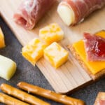 Closeup of kid friendly charcuterie board with meat, cheese, pretzels, and jam