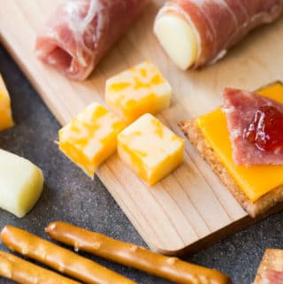 Closeup of kid friendly charcuterie board with meat, cheese, pretzels, and jam