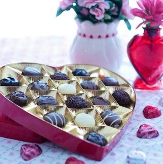 Red heart chocolate box with candy and flowers