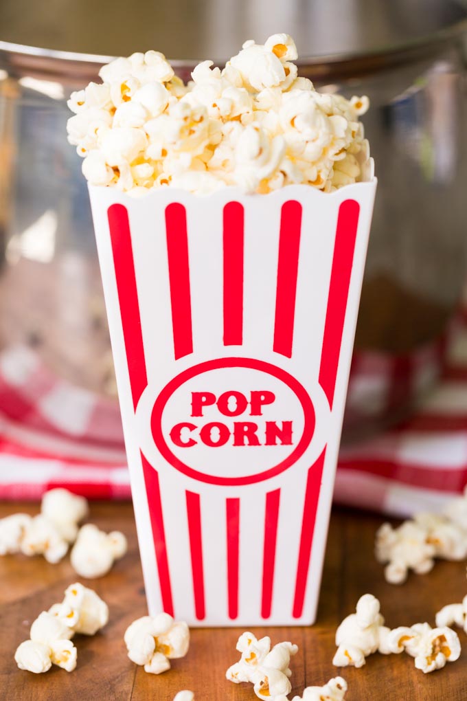 Movie theater popcorn in a red striped popcorn bucket