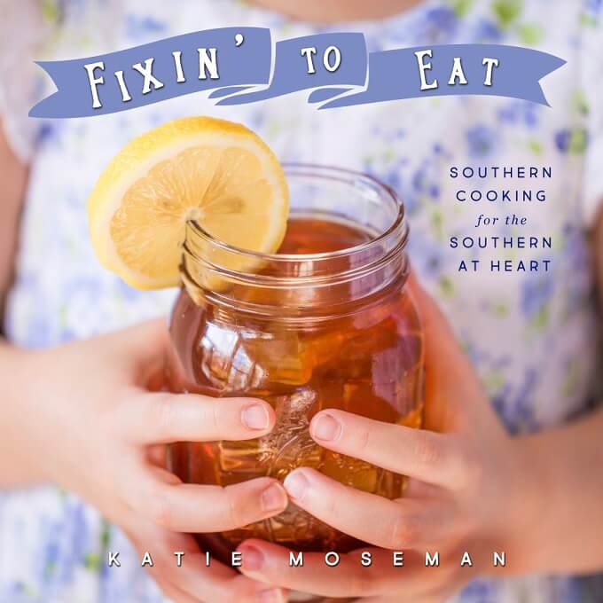 Child's hands holding mason jar of sweet tea with lemon, shown on the cover of Southern cookbook Fixin' to Eat