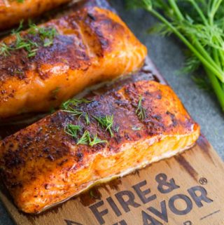 Cedar plank oven salmon on a plank with fresh dill garnish