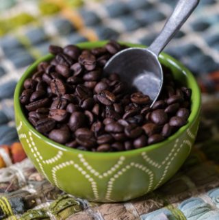 Shade grown coffee beans in a bowl with scoop