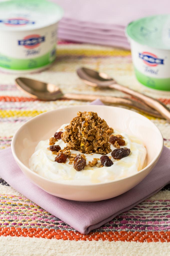 oatmeal raisin toppings on FAGE yogurt in a ceramic bowl