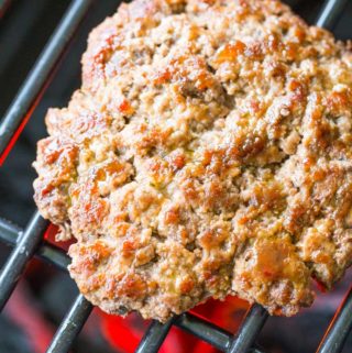 Grilling bison burgers on a lit charcoal grill