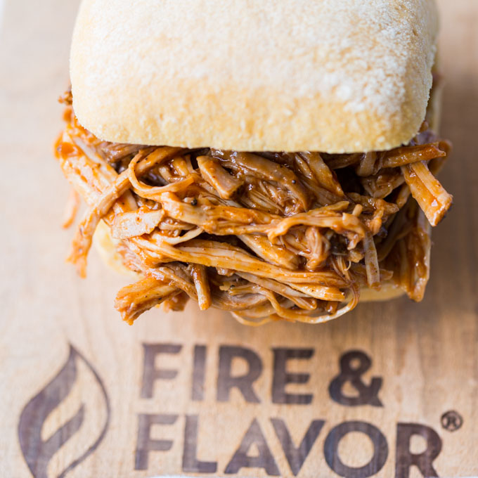 Oven pulled pork sandwich served on a wooden plank