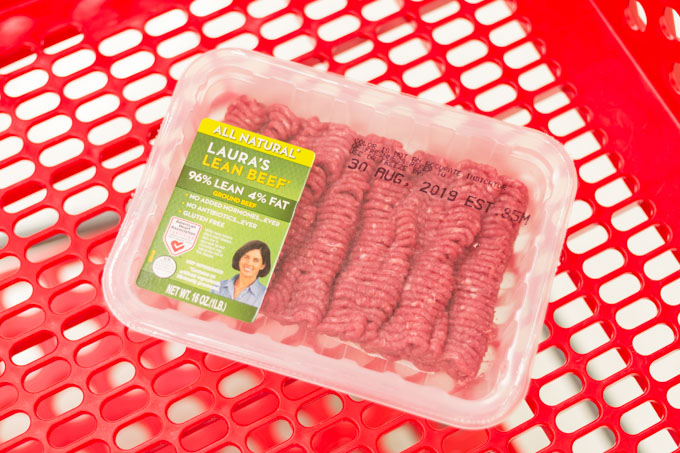 Package of ground beef in a red shopping cart