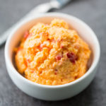 Scoop of hatch chile pimento cheese in a white bowl
