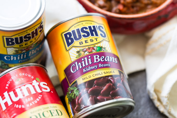 Ingredients for chili with potatoes including pinto beans in a can, kidney beans in a can, and canned diced tomatoes