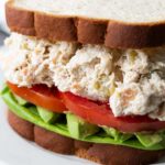 Green chile chicken salad sandwich on a white plate