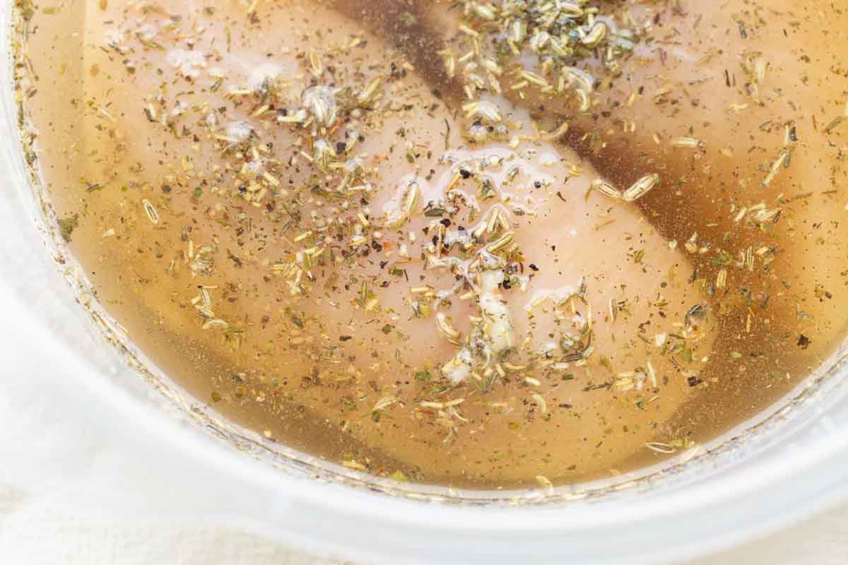 Chicken breasts in a container of liquid brine