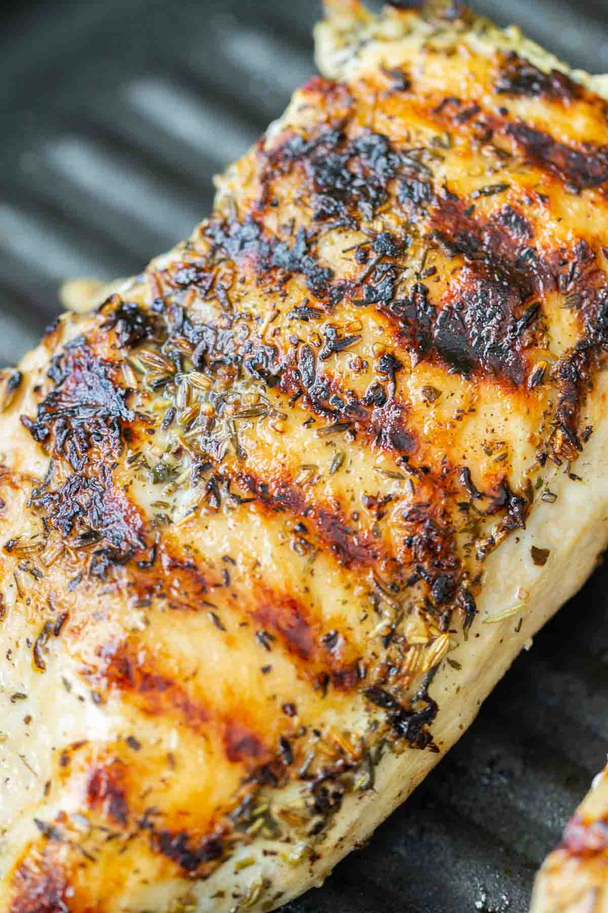 Cooked brined chicken breasts with sear marks in a grill pan